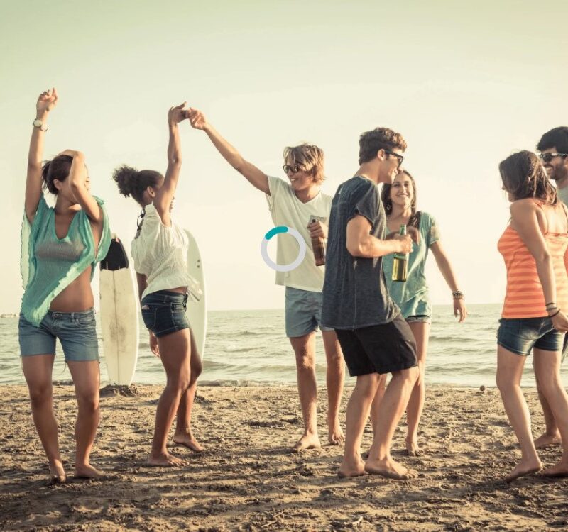 Group of young people dancing on the beach