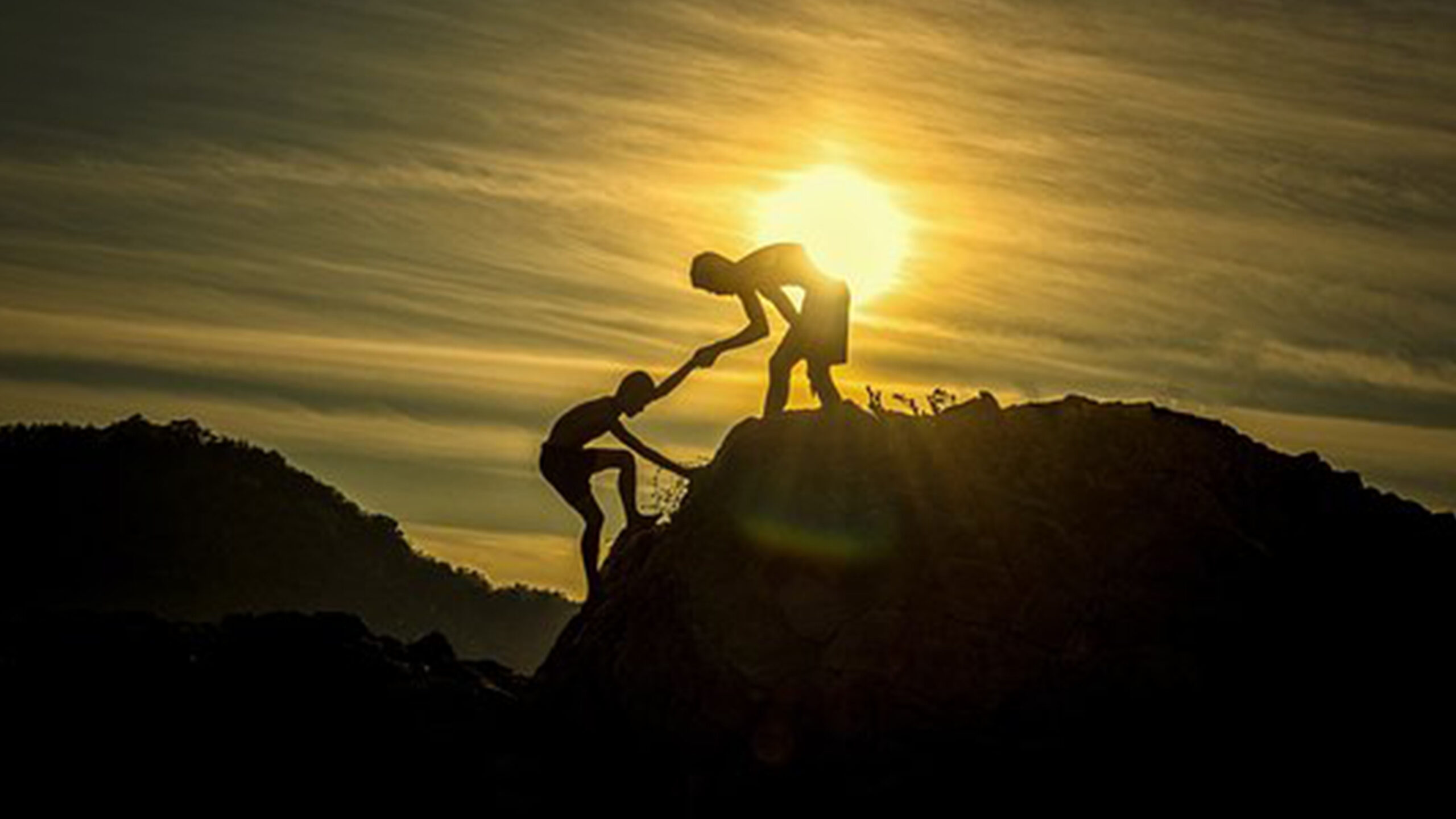 Helping Another to the Top of a Hill at Sundown