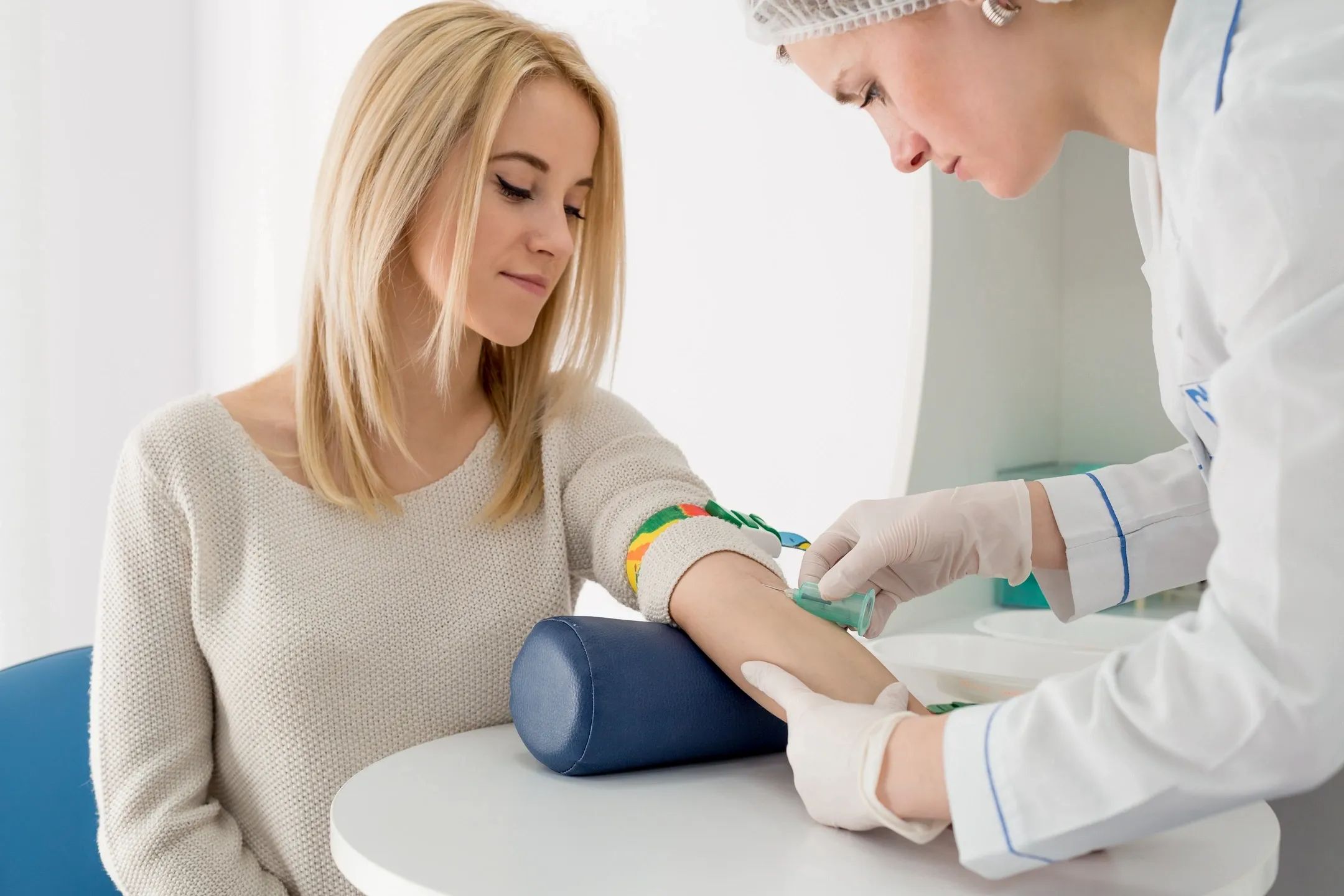 Medical personnel drawing blood from a patients arm