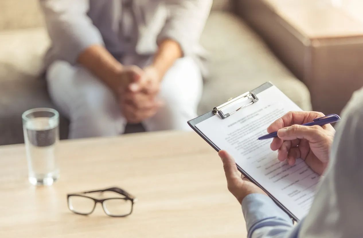 Doctor with a clipboard gathering medical history information from a patient