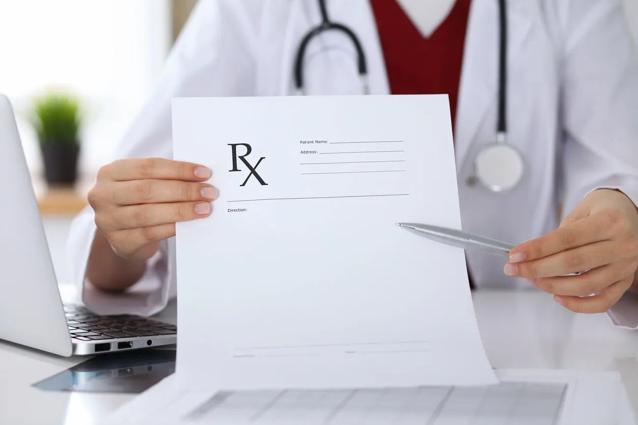 Doctor holding a blank prescription paper