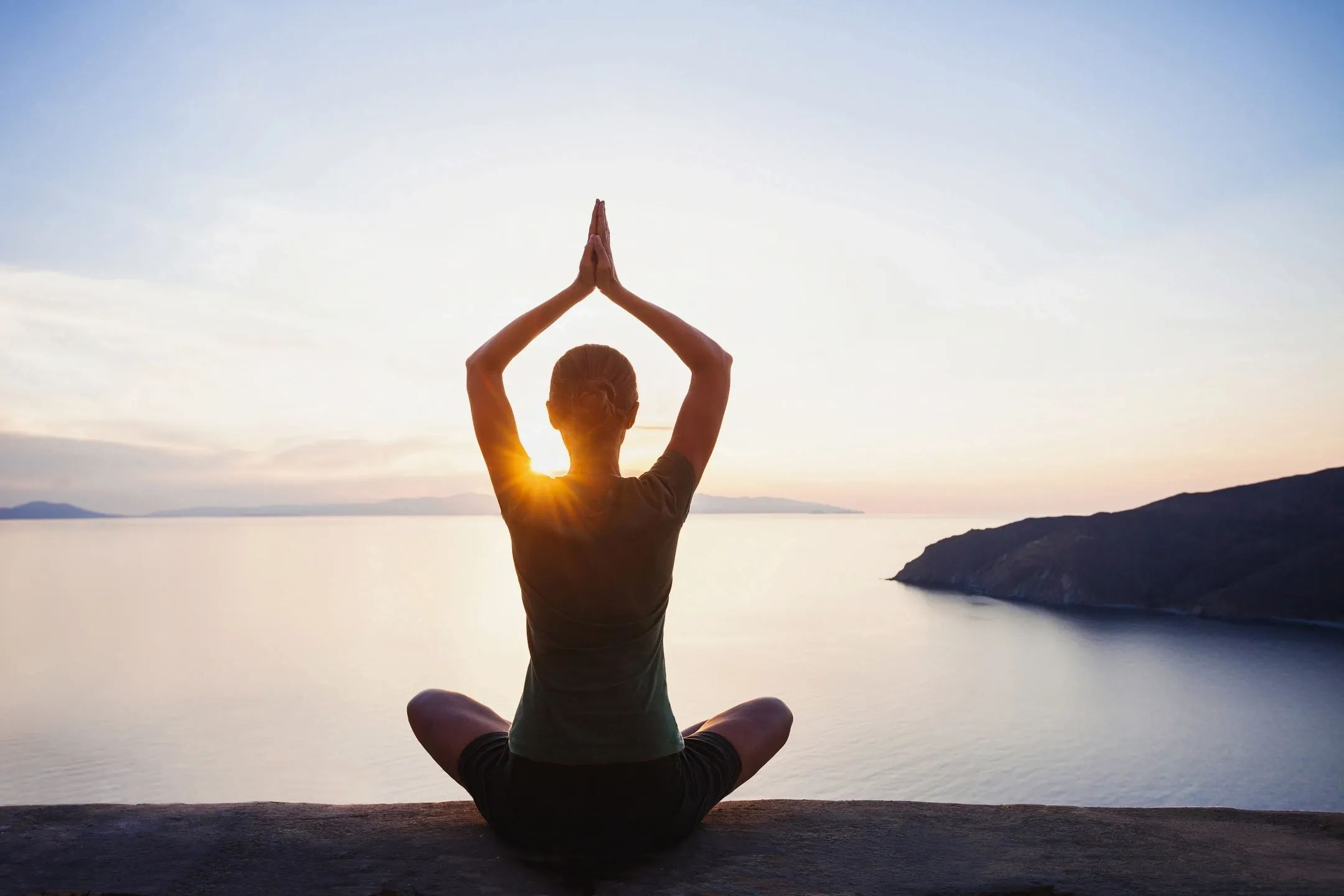 Young woman doing yoga with a beautiful landscape view