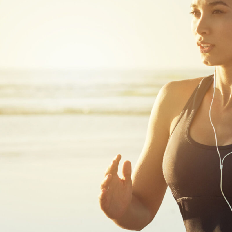 Young Fit Woman Jogging on Beach