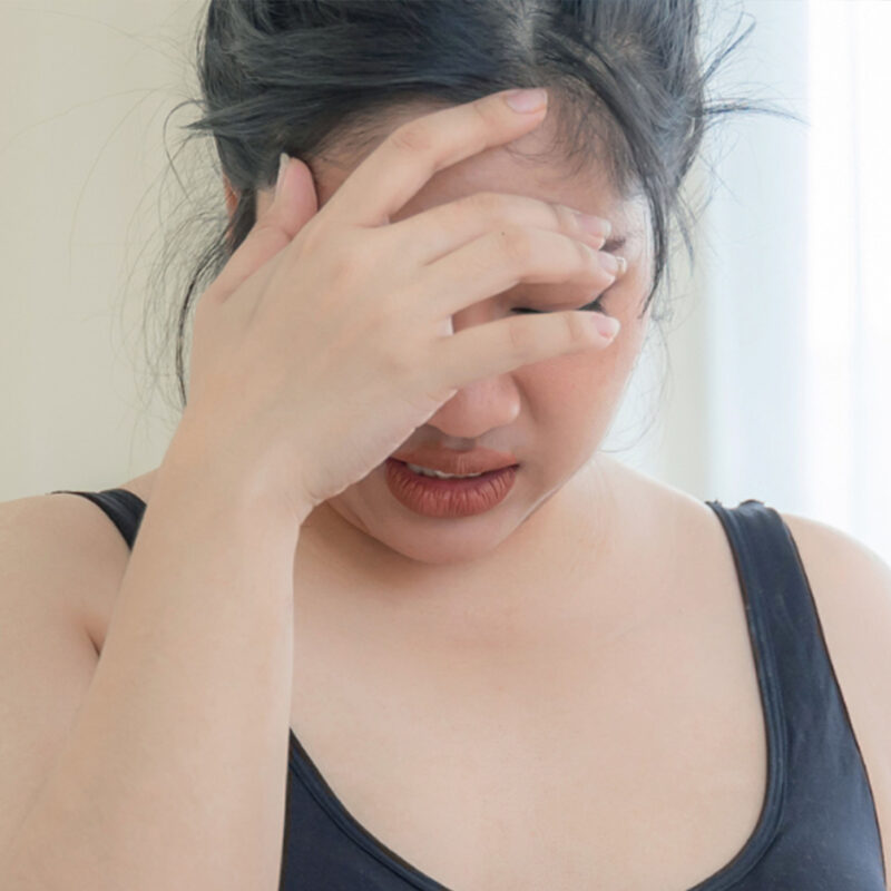 Asian Woman Upset with Hand Covering Forehead and Eyes