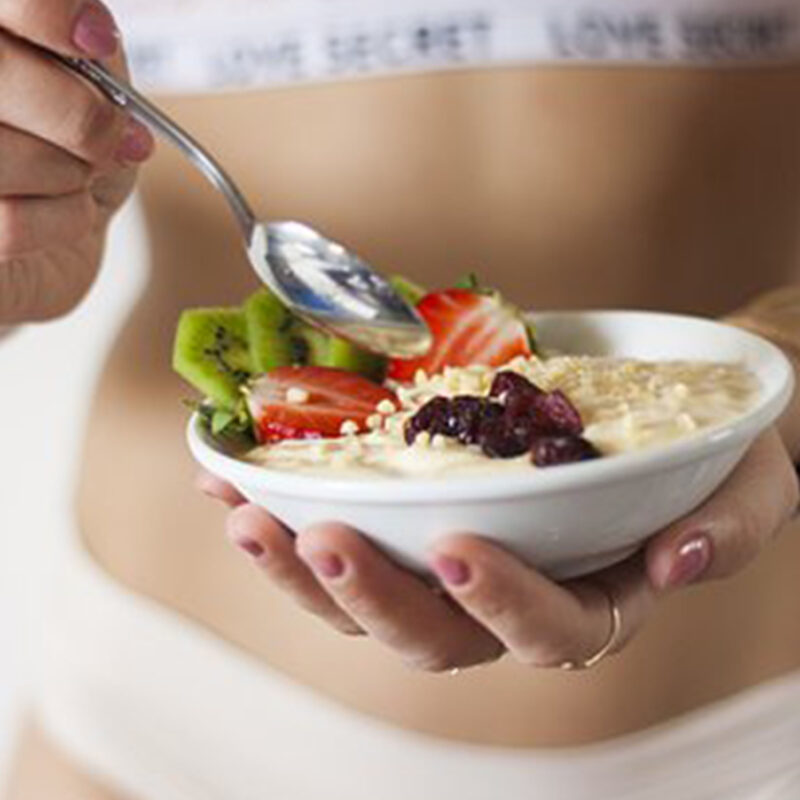 Woman Eating Cereal with Fruit